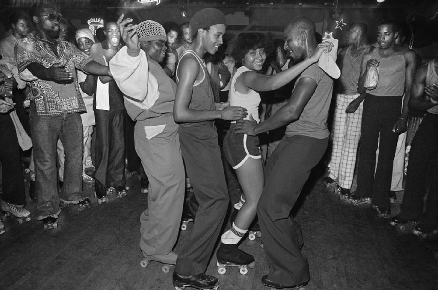 Dancers on roller skates moving together on a crowded nightclub floor.